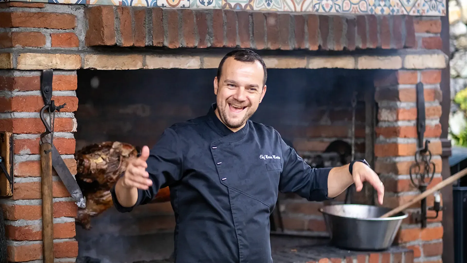 Koch lacht am Grill vor einer gefliesten Wand, Branding-Fotografie