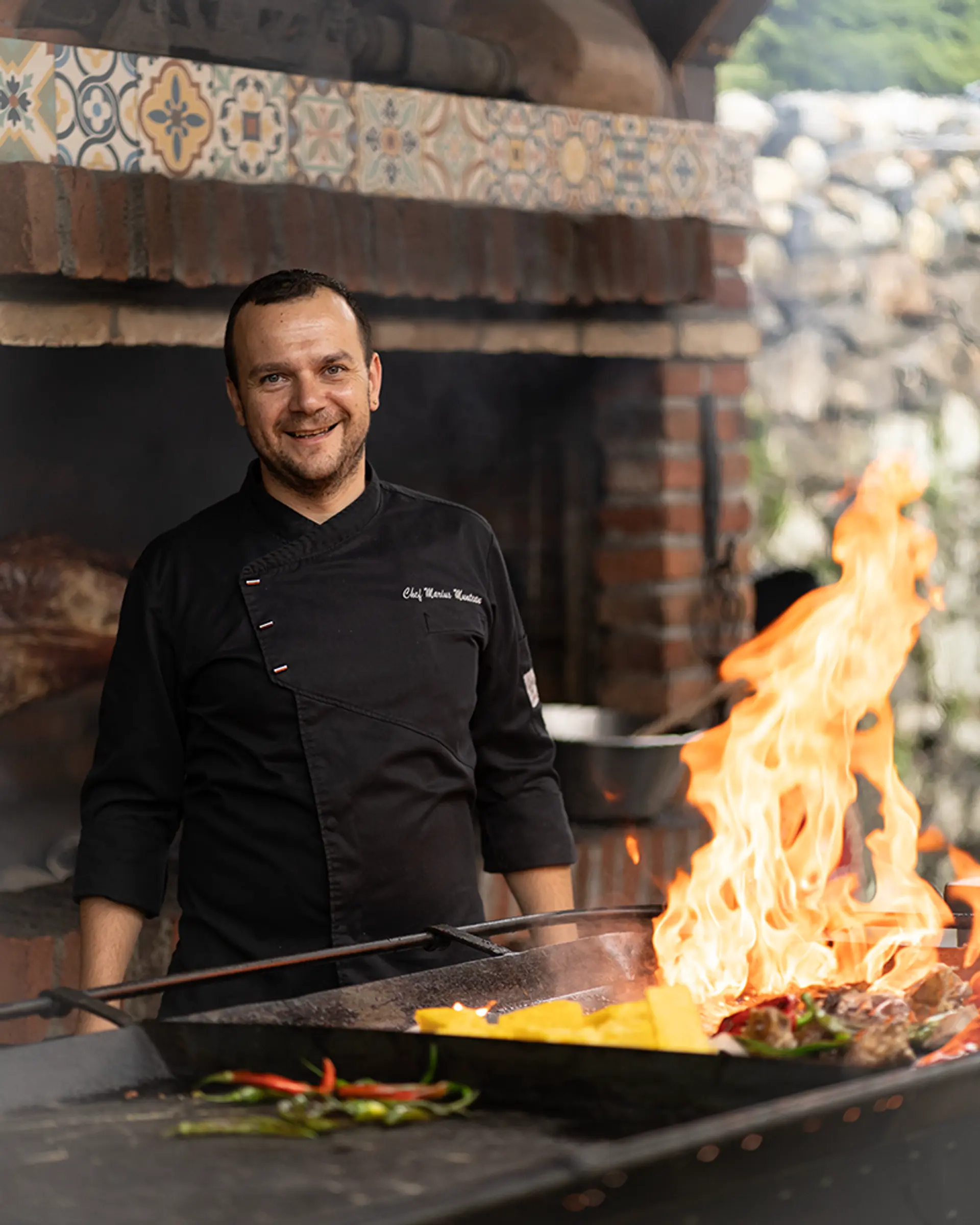 Koch am offenen Grill mit Flammen, Branding-Fotografie