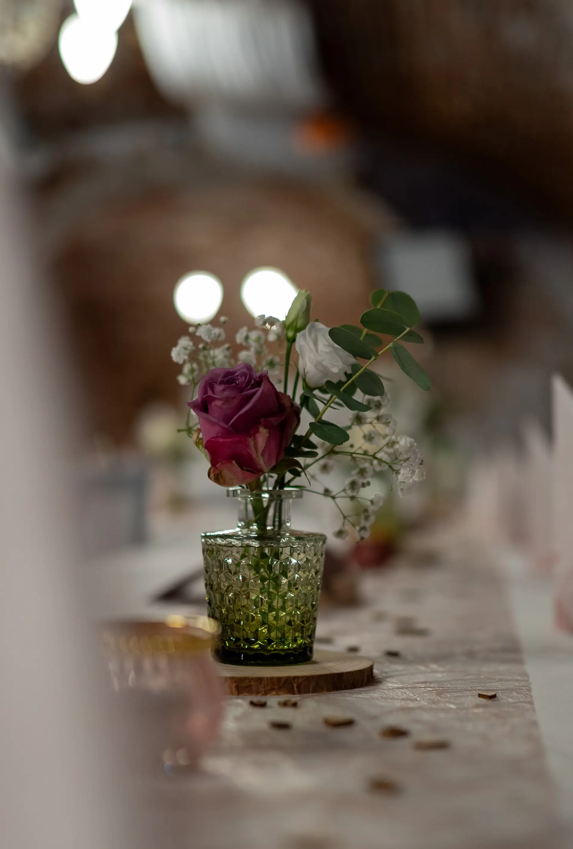 Tischdekoration mit Rose in einer Glasvase auf der Hochzeitstafel