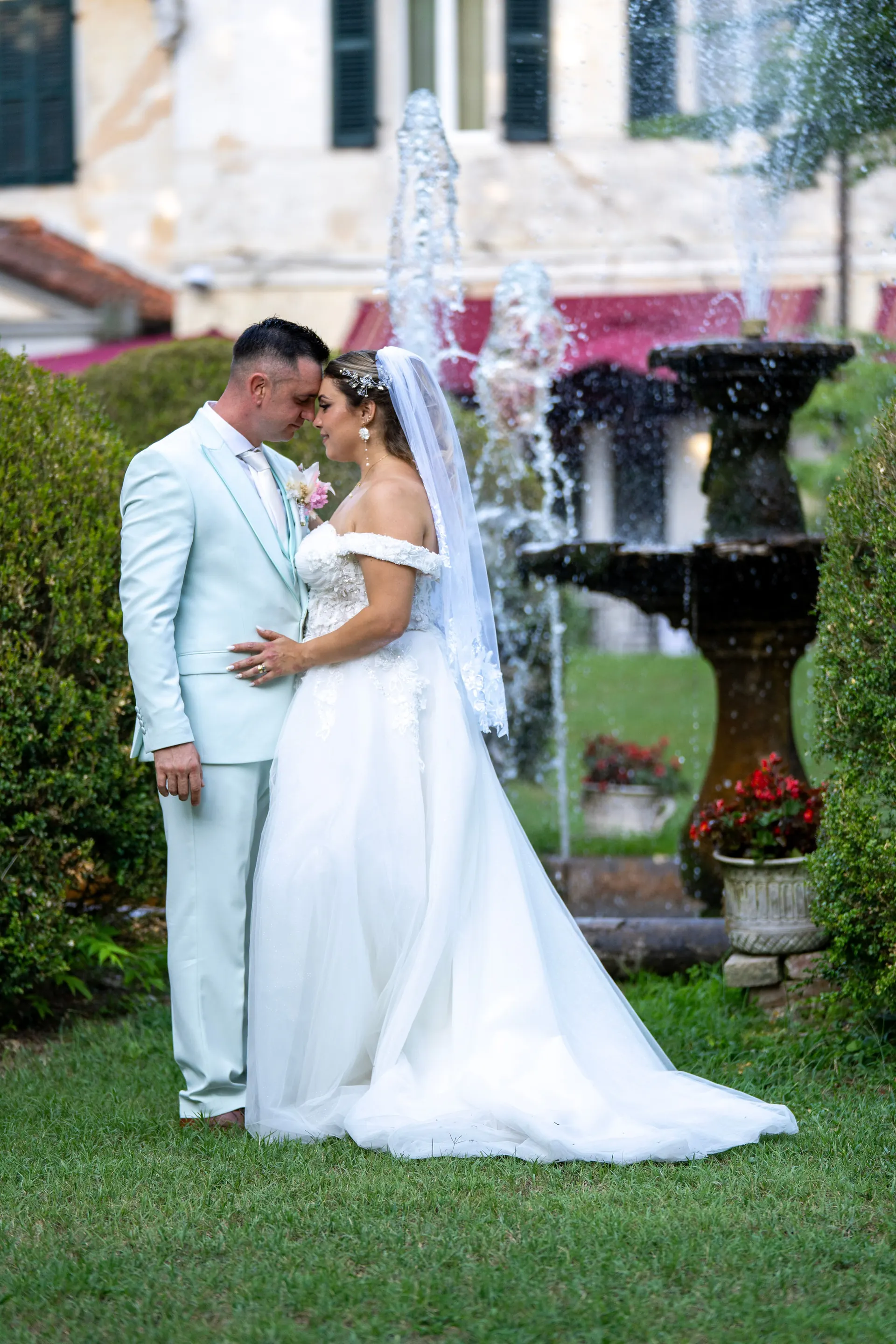 Brautpaar umarmt sich am Brunnen vor der Villa Luppis in Italien
