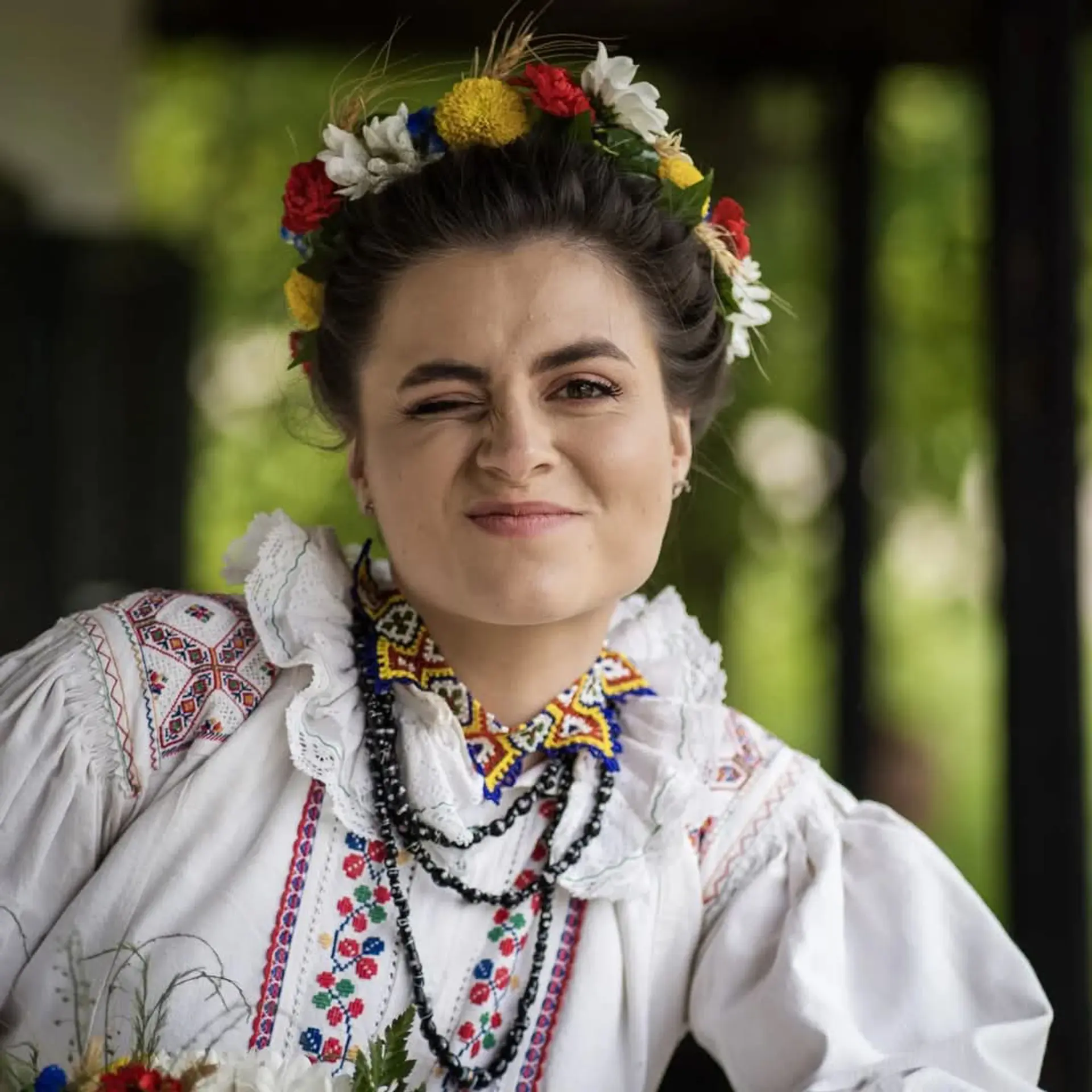 Frau in Tracht zwinkert lachend in die Kamera